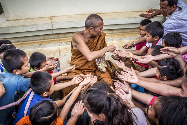 Mnich rozdává dětem jídlo